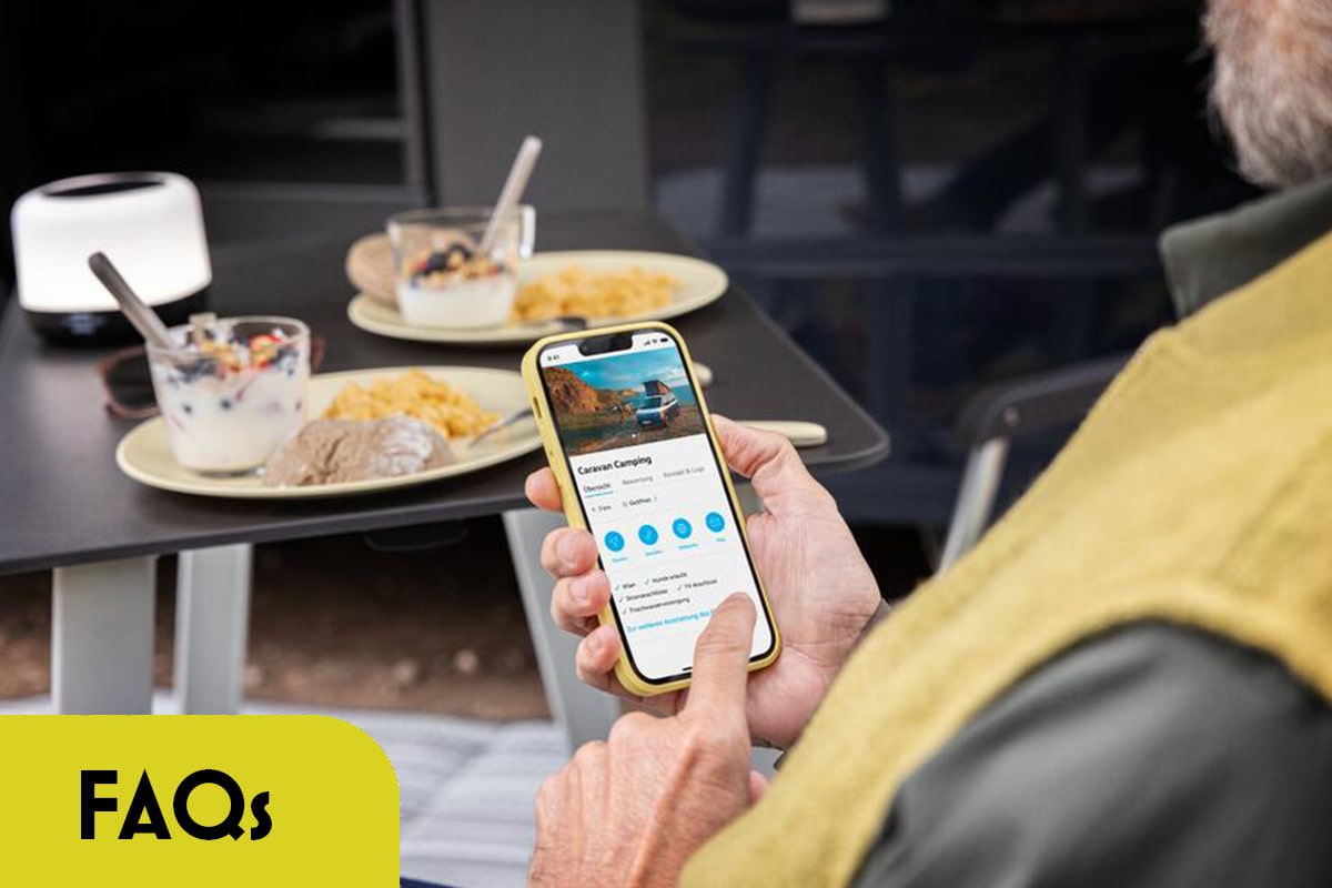 Ein Mann sitzt im Café und schaut auf sein Handy.